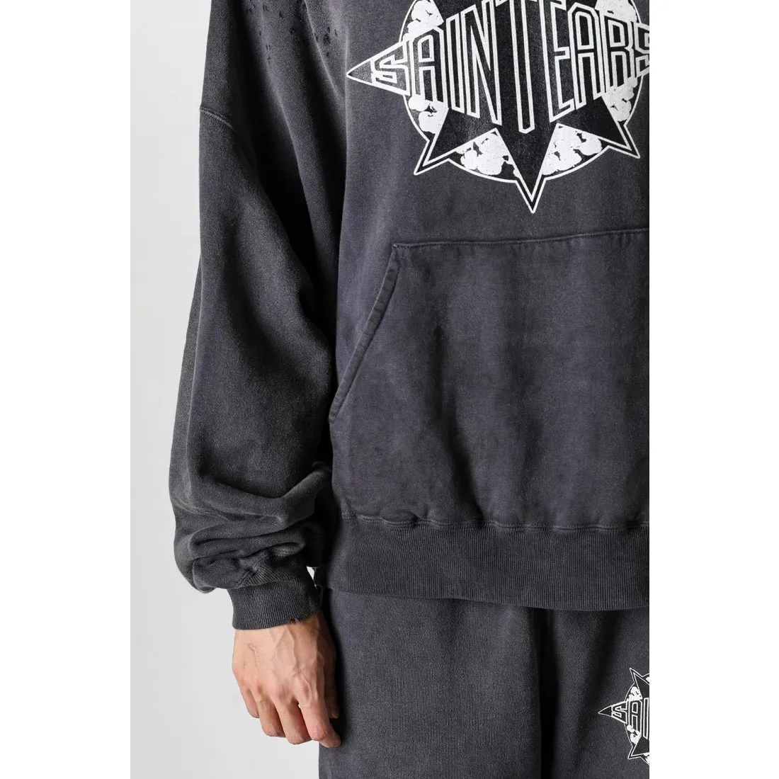 DENIM TEARS x SAINT Mxxxxxx SAINT TEARS Hoodie/BLK Five-pointed star cotton hole-in-the-dark distressed hoodie, washed black S-XL Assute dyeing, whole piece sprayed with horse fade/horse weight, co-branded main mark/cotton wash mark/cherub mark, many hanging holes on the front and rear panels, the original version has the same loose fit